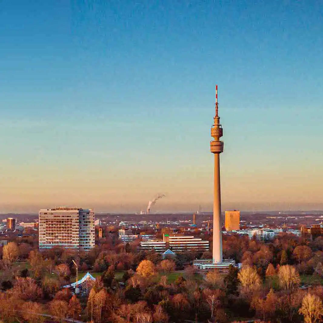 Fernsehturm in Dortmund, umgeben von herbstlich gefärbten Bäumen und urbaner Skyline